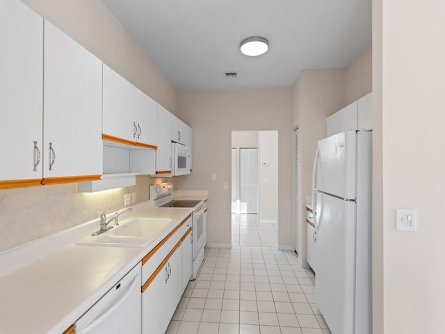 kitchen with visible vents, a sink, white appliances, white cabinets, and light countertops