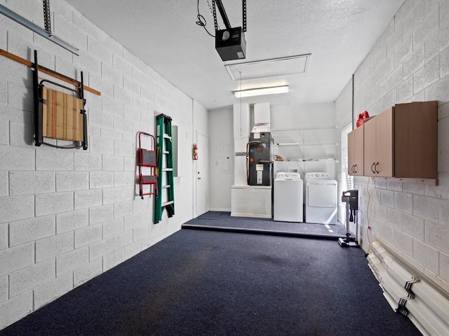 garage with heating unit, a garage door opener, washing machine and dryer, and concrete block wall