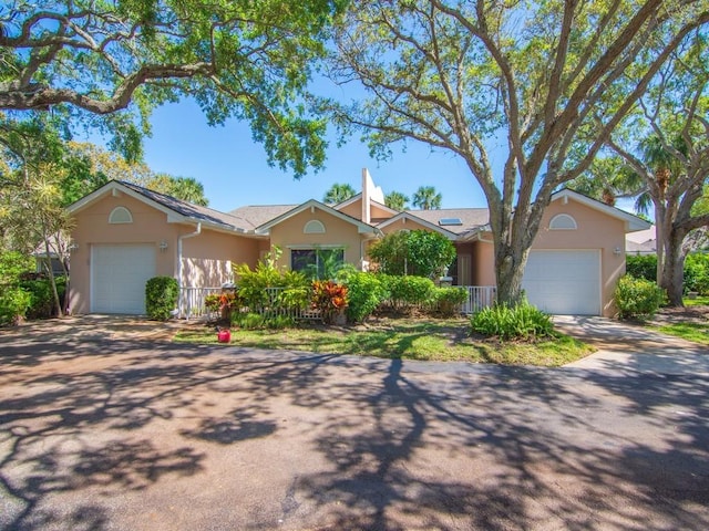 ranch-style house with a garage, concrete driveway, and stucco siding