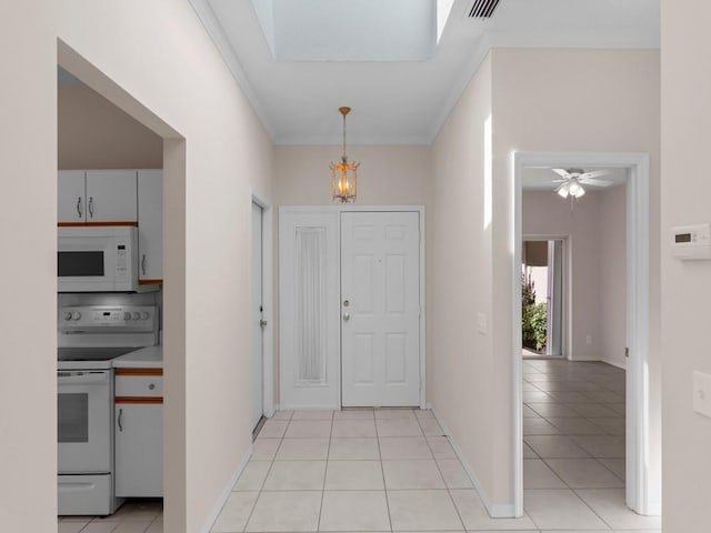 interior space featuring light tile patterned floors, visible vents, baseboards, and ornamental molding