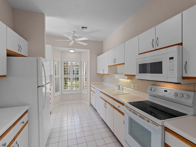 kitchen featuring visible vents, white appliances, light countertops, and a sink