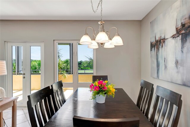 tiled dining area with french doors and an inviting chandelier