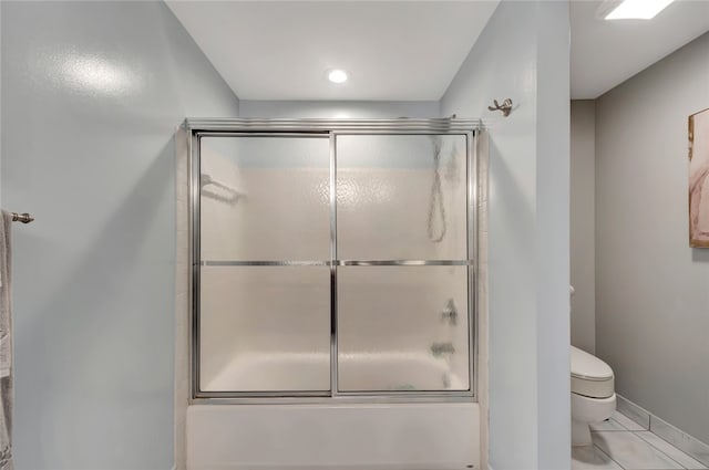 bathroom featuring bath / shower combo with glass door and toilet