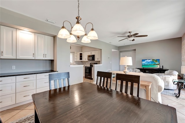 dining room featuring ceiling fan with notable chandelier and light tile patterned floors