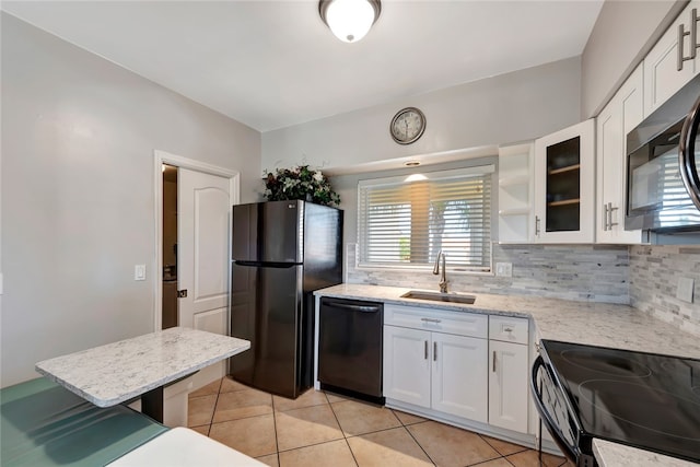 kitchen featuring black appliances, backsplash, light tile patterned floors, sink, and white cabinets