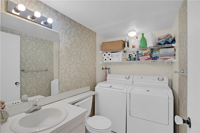 bathroom featuring toilet, vanity, and separate washer and dryer