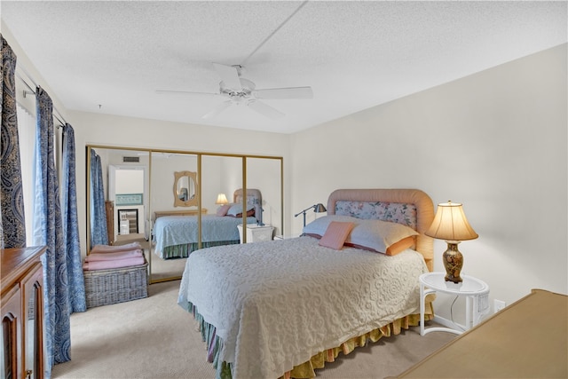 carpeted bedroom with a closet, a textured ceiling, and ceiling fan