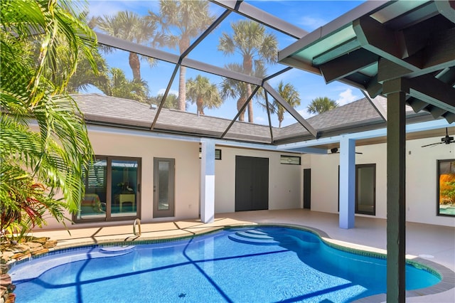 view of pool with glass enclosure, a patio, and ceiling fan