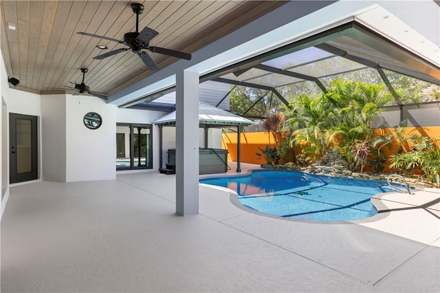 view of swimming pool with a lanai, ceiling fan, and a patio area