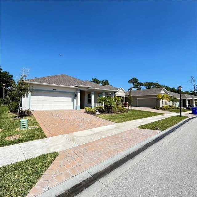 3577 Loblolly Sq, Vero Beach, FL 32966 - single story home featuring decorative driveway, an attached garage, stucco siding, and a front yard
