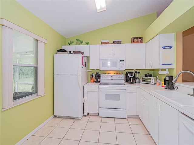 kitchen featuring light tile patterned flooring, white cabinetry, sink, white appliances, and lofted ceiling