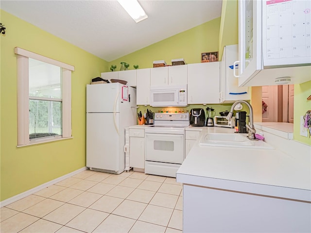 kitchen featuring white cabinetry, light tile patterned floors, sink, vaulted ceiling, and white appliances