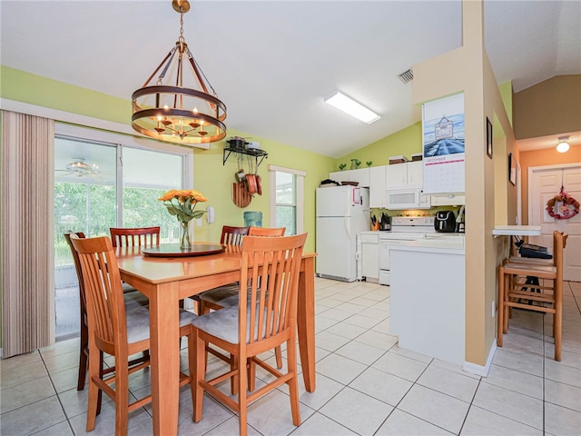 dining area with light tile patterned floors, an inviting chandelier, and lofted ceiling