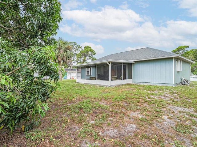 rear view of property featuring a lawn and a sunroom