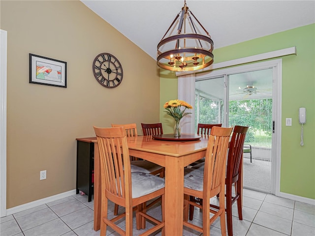 tiled dining space with ceiling fan with notable chandelier and vaulted ceiling