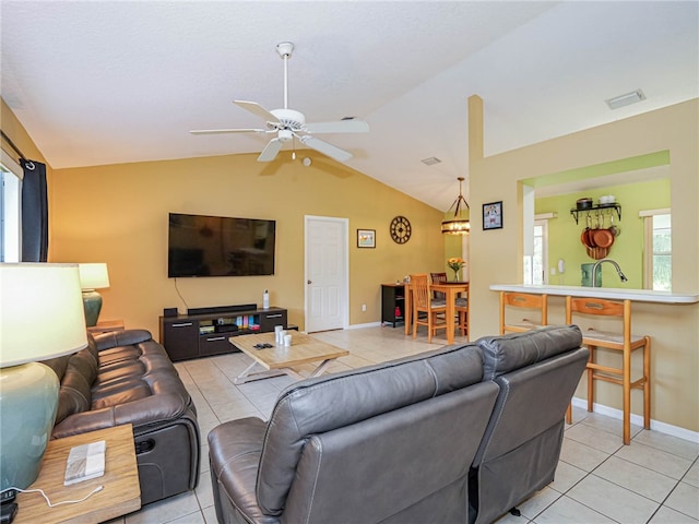 tiled living room featuring ceiling fan, a healthy amount of sunlight, and lofted ceiling