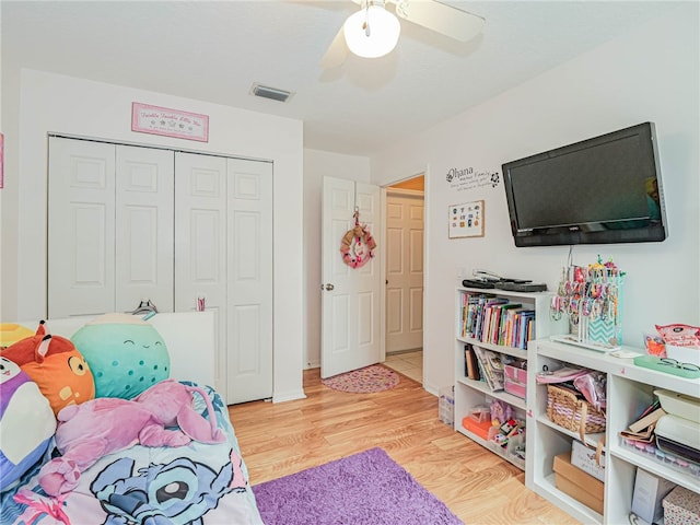 bedroom with a closet, hardwood / wood-style flooring, and ceiling fan