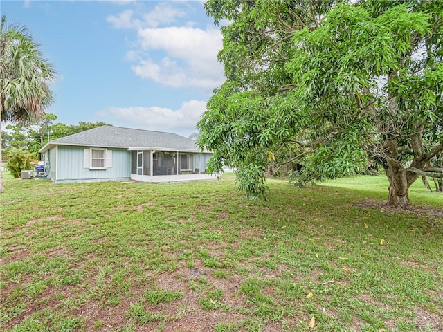 rear view of property featuring a sunroom and a yard