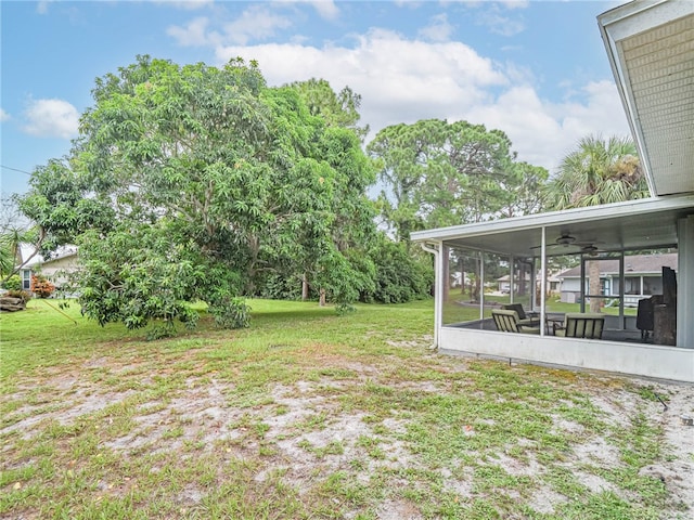 view of yard with ceiling fan and a sunroom