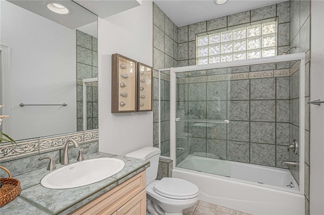 bathroom featuring vanity, tile patterned flooring, toilet, and shower / bath combination with glass door
