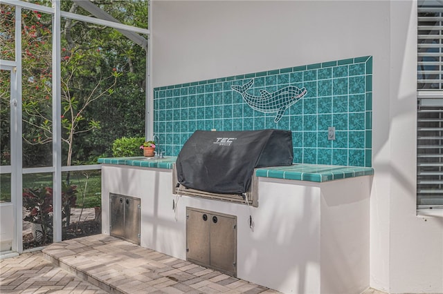 view of patio with an outdoor kitchen and a grill