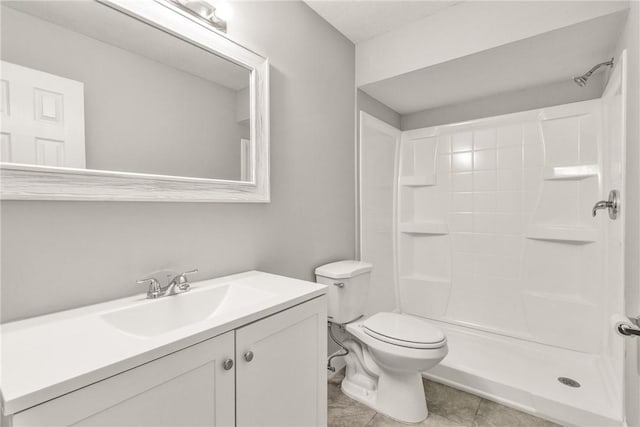 bathroom featuring tile patterned flooring, vanity, toilet, and a shower