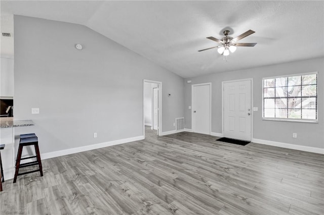 unfurnished living room with ceiling fan, light hardwood / wood-style floors, and lofted ceiling