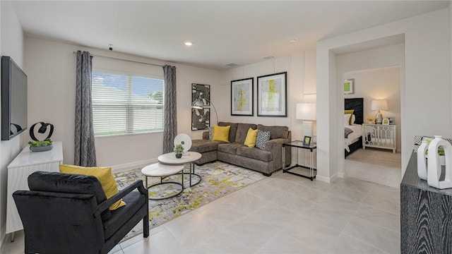 living room featuring light tile patterned floors, visible vents, and baseboards