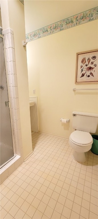 bathroom with toilet, tile patterned floors, and a shower with door