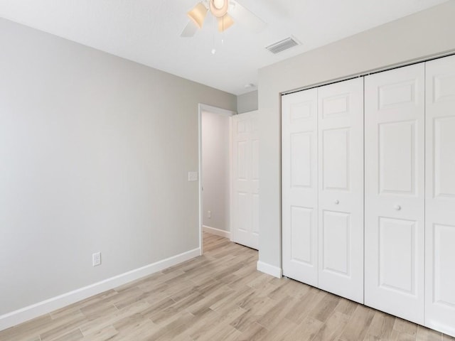 unfurnished bedroom featuring ceiling fan, light hardwood / wood-style floors, and a closet