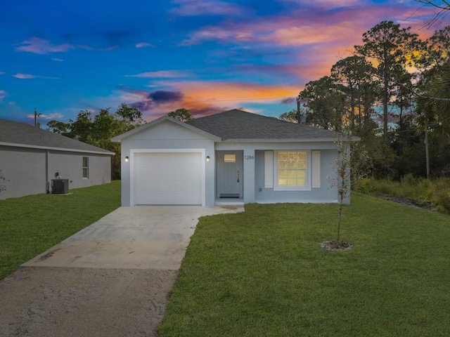 ranch-style house featuring a garage, cooling unit, and a lawn