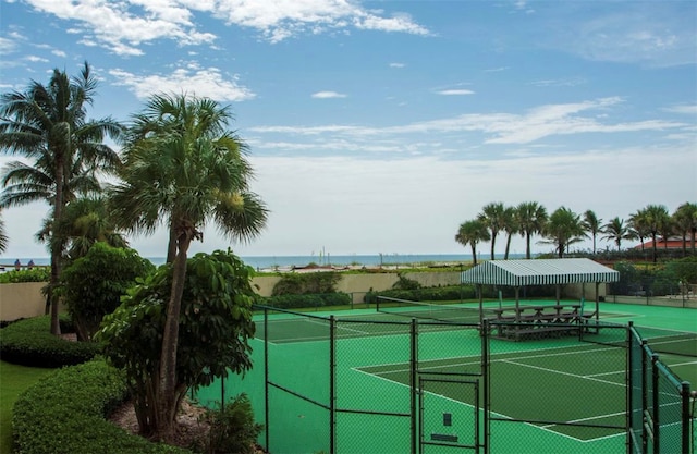 view of tennis court featuring a water view