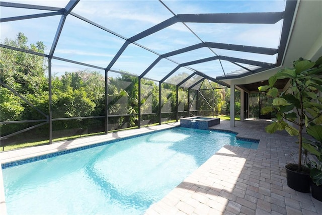 view of swimming pool featuring a patio area, glass enclosure, and a pool with connected hot tub