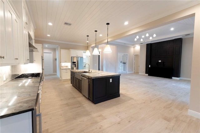 kitchen featuring white cabinets, stainless steel appliances, visible vents, and dark cabinetry