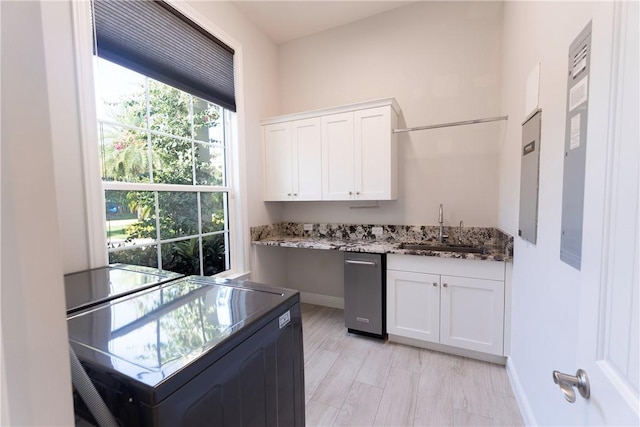 kitchen featuring white cabinets, a sink, stone counters, baseboards, and stove