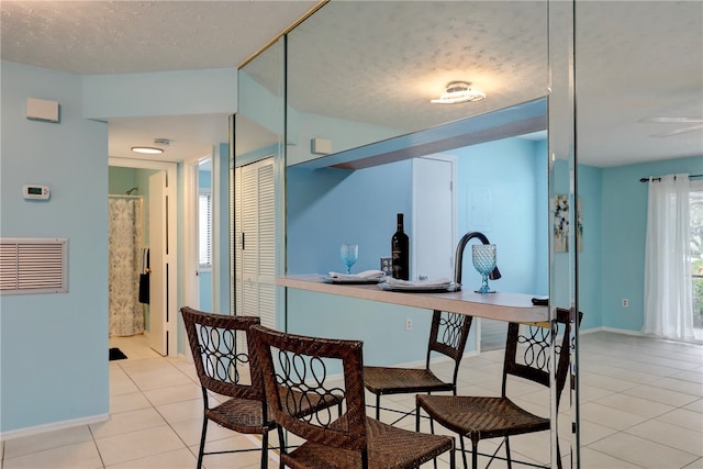 kitchen with a textured ceiling and light tile patterned floors