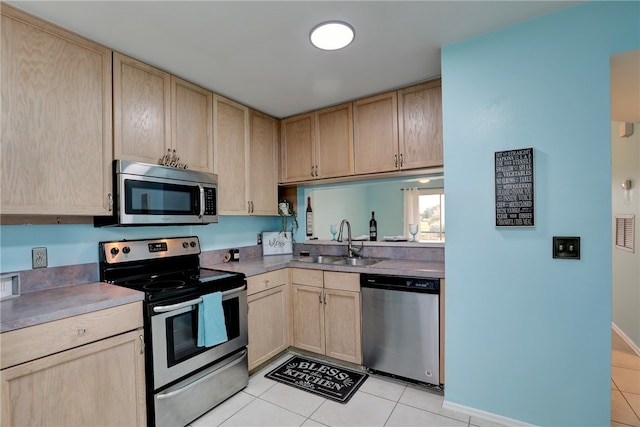 kitchen featuring light brown cabinetry, appliances with stainless steel finishes, sink, and light tile patterned floors