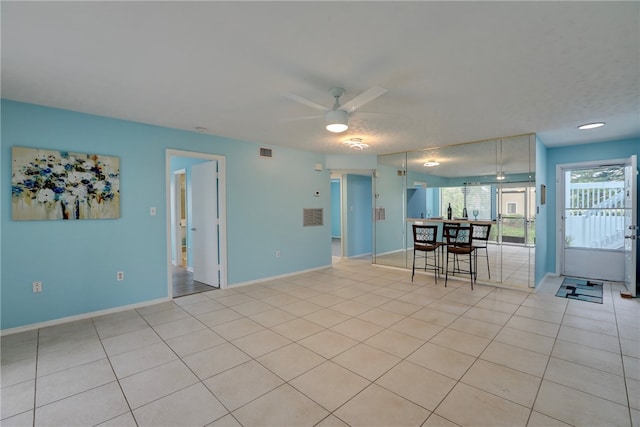 interior space with light tile patterned flooring and ceiling fan