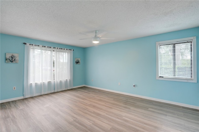 empty room featuring light hardwood / wood-style floors, ceiling fan, and a textured ceiling