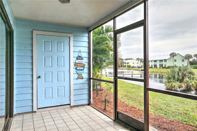 unfurnished sunroom featuring a water view