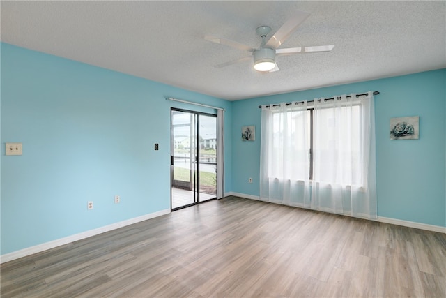 empty room featuring a textured ceiling, ceiling fan, and light hardwood / wood-style flooring