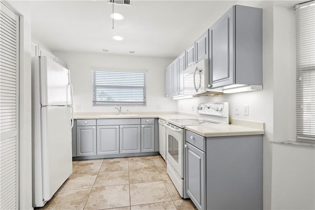 kitchen featuring gray cabinetry, white appliances, and sink