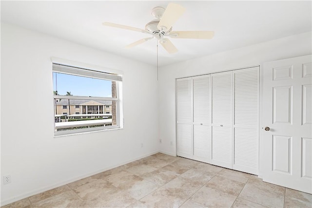 unfurnished bedroom with ceiling fan and a closet