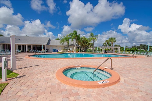 view of swimming pool with a hot tub