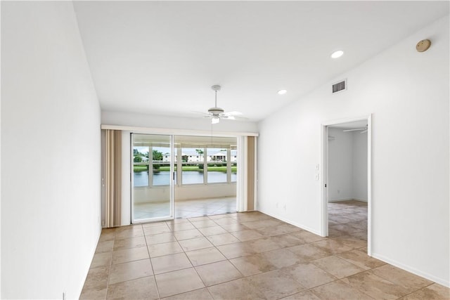 spare room featuring ceiling fan, a water view, lofted ceiling, and light tile patterned floors