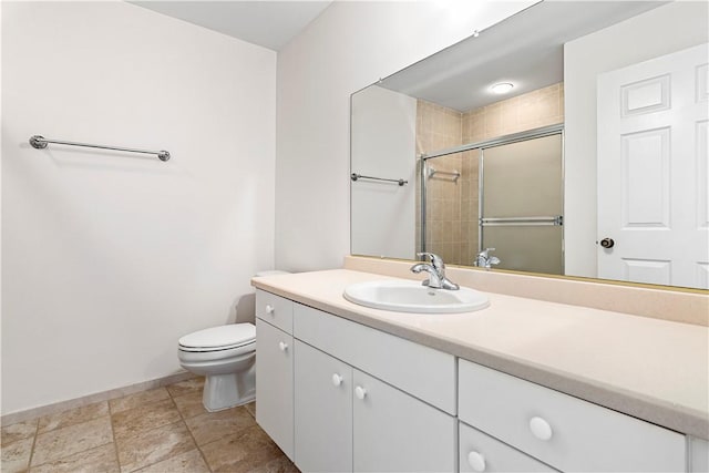 bathroom featuring vanity, toilet, and a shower with door