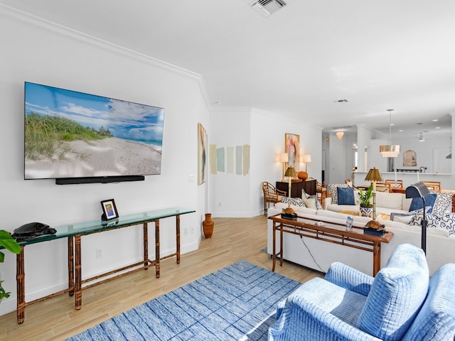 living room featuring light wood-type flooring and ornamental molding