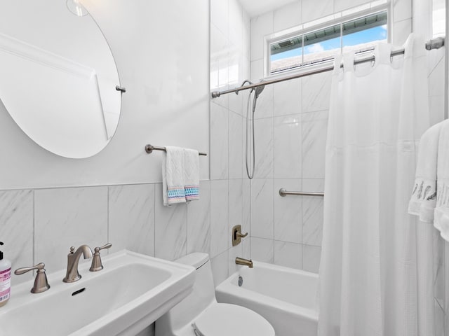 full bathroom featuring tile walls, toilet, shower / bath combination with curtain, and sink