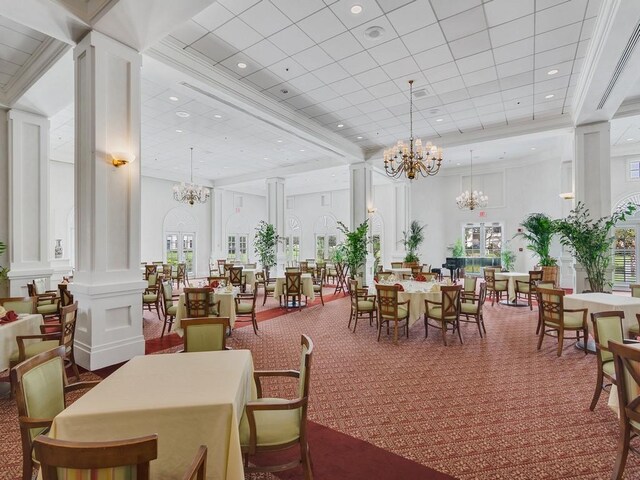 dining space with a towering ceiling, decorative columns, and carpet floors