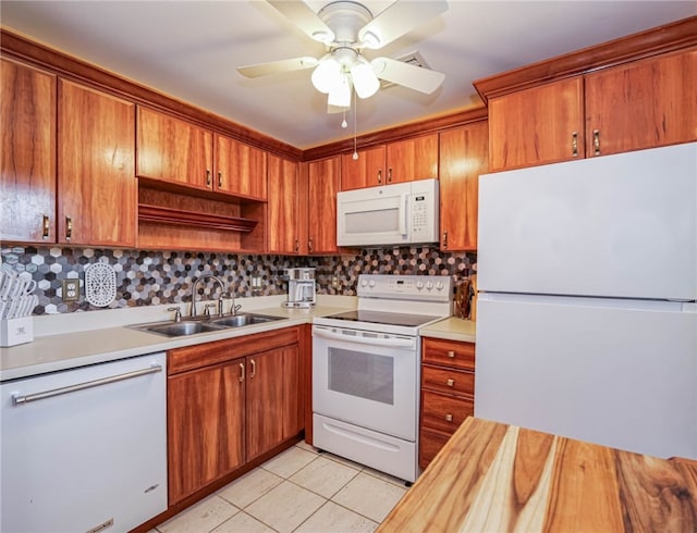 kitchen with tasteful backsplash, white appliances, ceiling fan, sink, and light tile patterned floors